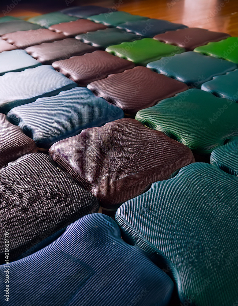 Obraz premium A close-up of interlocking foam tiles on a gym floor provides a safe and cushioned surface for floor exercises and stretching.