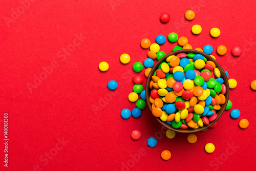 Multicolored candies in a bowl on a colored background. birthday and holiday concept. Top view with copy space