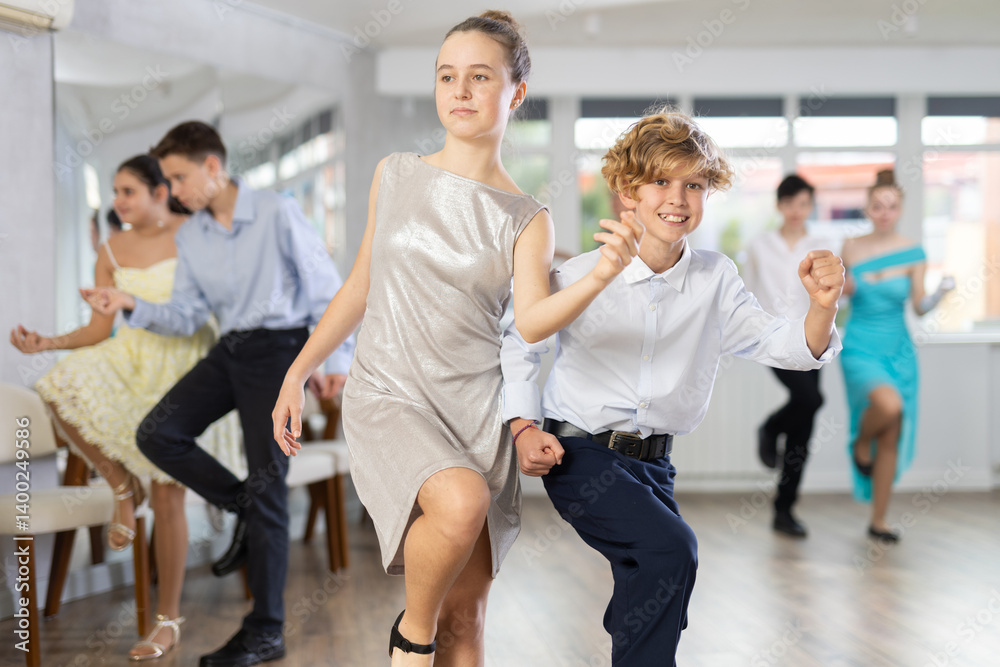 Fototapeta premium Happy teenage boys and beautiful girls dance a fiery twist dance