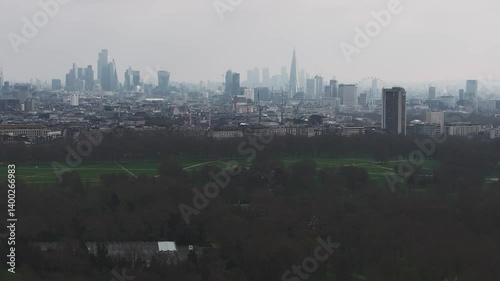 Aerial view of London featuring the Shard, Walkie Talkie, and a large park. The camera pans across the skyline under an overcast sky.