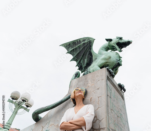 Young woman taking photo in front famous Dragon bridge in Ljubljana. Travel Explore Slovenia, Europe