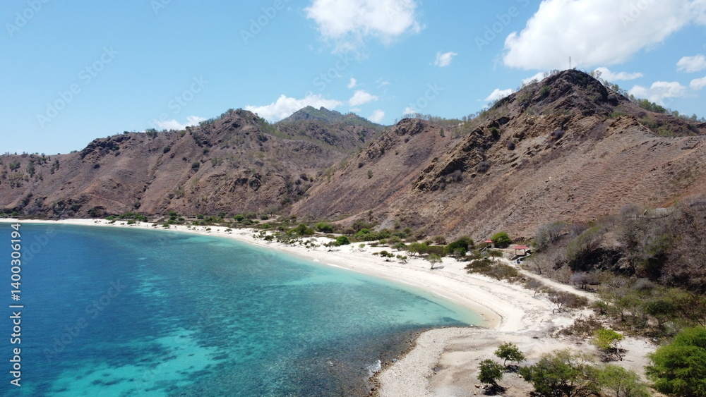 Aerial scenic view of Dili, Timor-Leste with white sandy beach and exotic crystal clear turquoise ocean water with rugged mountainous terrain Aerial scenic view of Dili, Timor-Leste with white sandy beach and exotic crystal clear turquoise ocean water with rugged mountainous terrain
