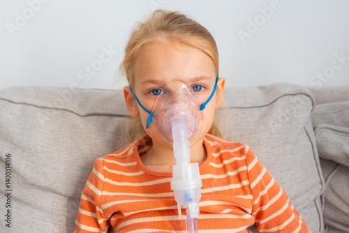 Young girl using a nebulizer at home during a respiratory treatment session in a cozy living room setting