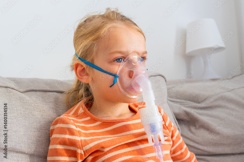 Young child using a nebulizer at home while resting on a couch in the living room during the day