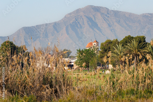 Paisaje con la montaña de Crevillente y el campanario de la población San Felipe Neri desde el parque natural el Hondo, España photo