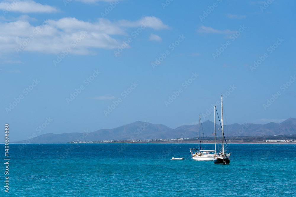 Yachts in the sea against distant shore Yachts in the sea against distant shore