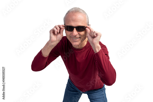 Senior man lowering sunglasses and smiling on white background