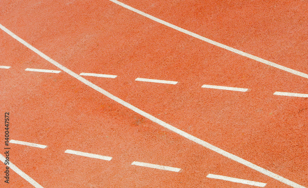 Fototapeta premium White lines marking running tracks on red surface of outdoor stadium