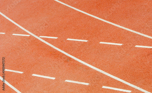 White lines marking running tracks on red surface of outdoor stadium