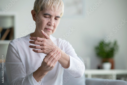 Wallpaper Mural Asian senior woman suffering from pain in her wrist at home. Arthritis symptoms Torontodigital.ca