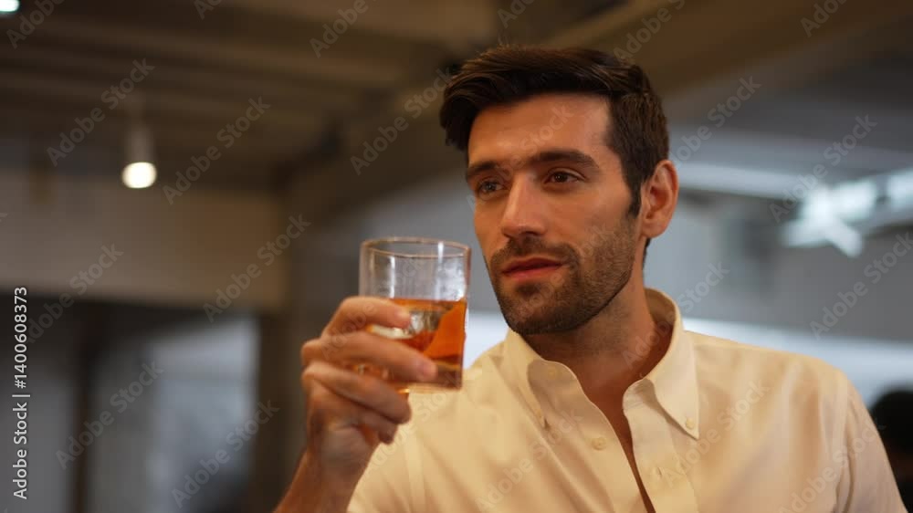 Profile closeup of smiling smart man in white shirt drinking cocktail in Old fashioned of special party beverage vibrant at nightclub on Friday meeting night time at luxurious counter bar. Vinosity. Profile closeup of smiling smart man in white shirt drinking cocktail in Old fashioned of special party beverage vibrant at nightclub on Friday meeting night time at luxurious counter bar. Vinosity.