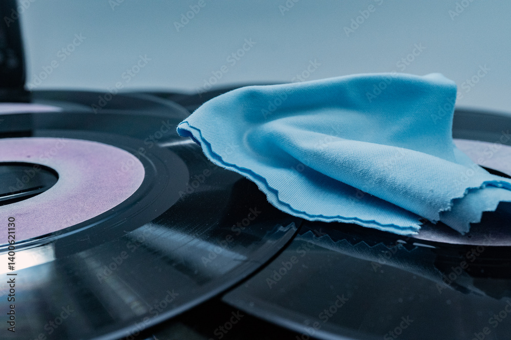 Blue microfiber cloth placed on vinyl records, ensuring dust free playback and preserving sound quality
