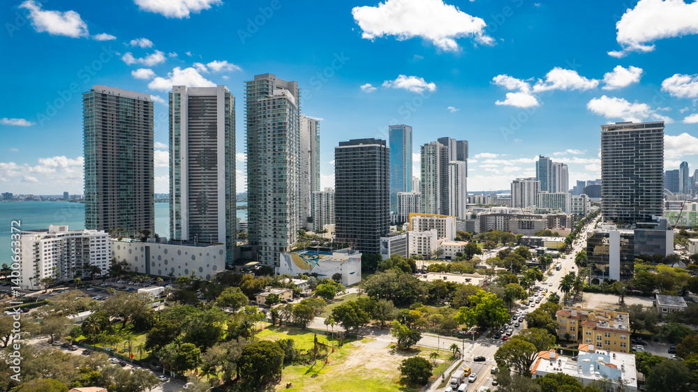 Obraz premium Miami, Florida - Feb 11, 2025: Aerial view of Edgewater condos from Midtown Miami with Biscayne Bay and high-rise skyline