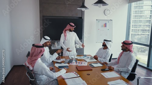 Cinematic video of a group of businessmen from Saudi arabia and Dubai during an corporate meeting in an office. Mixed business team from different parts of the UAE working together.