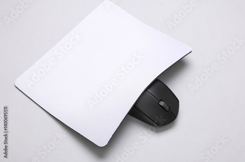 Mockup of white blank computer mouse pad or mat with wireless mouse on gray background