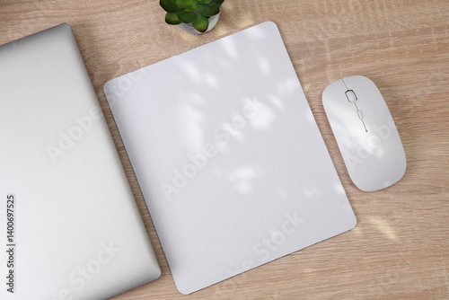 Mockup of white blank computer mouse pad or mat with props, mouse and laptop on table. Top view. Flat lay