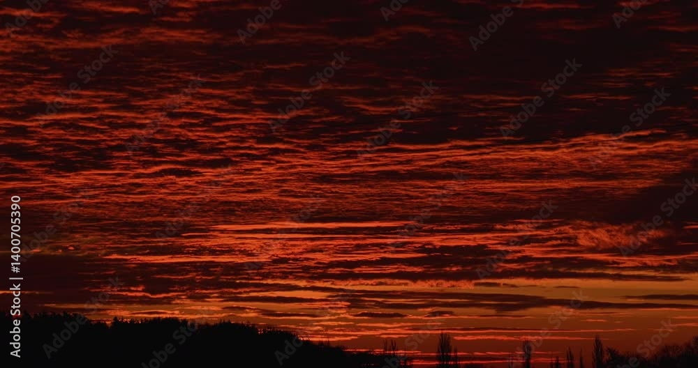 Timelapse close-up of the red sky before sunrise with dramatic orange glow contrasting with dark horizon