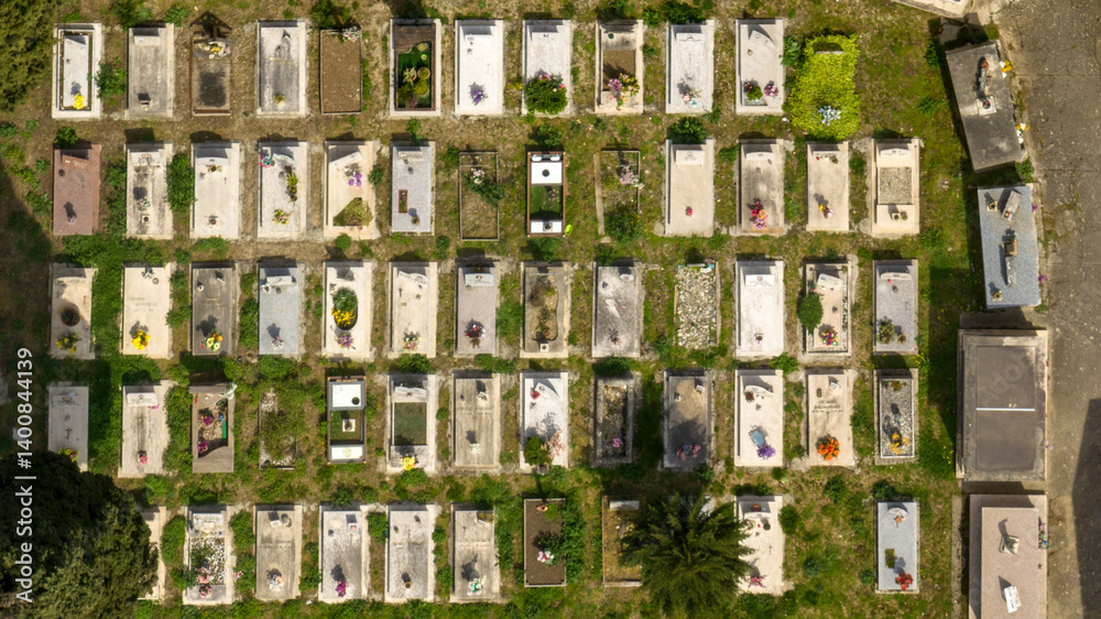 Aerial perpendicular view of graves in a meadow in a cemetery.