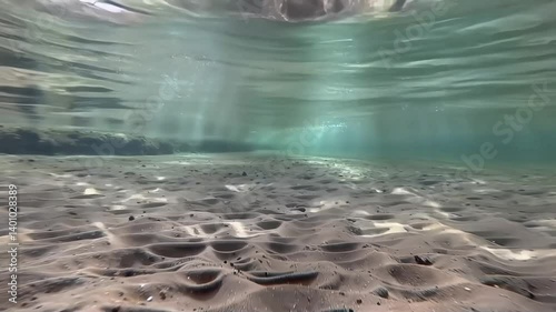 Tranquil underwater scene with sunbeams on a sandy seabed