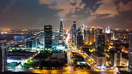 Vibrant illuminated cityscape at night under a cloudy sky
