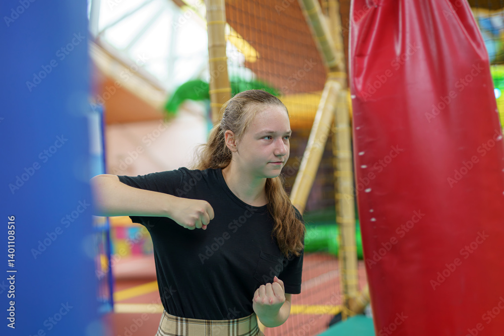 Obraz premium A girl punches a punching bag at a play park.
