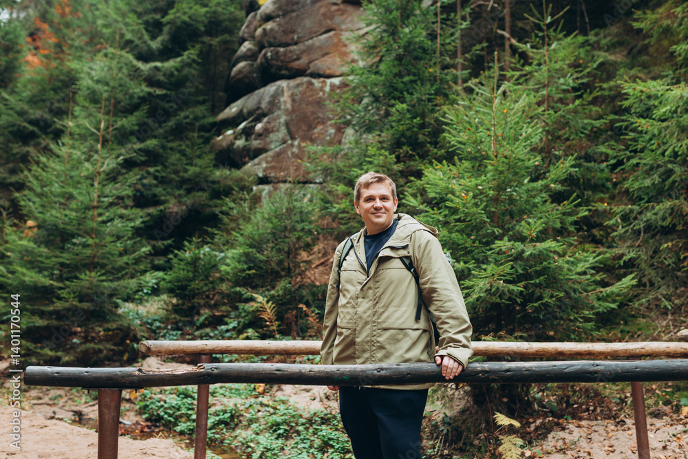 Young 30s blonde man hiking in nature. Travel, adventure. Concept of an active lifestyle. High quality photo. Fall autumn hiker man outdoor at nature forest. Full body
