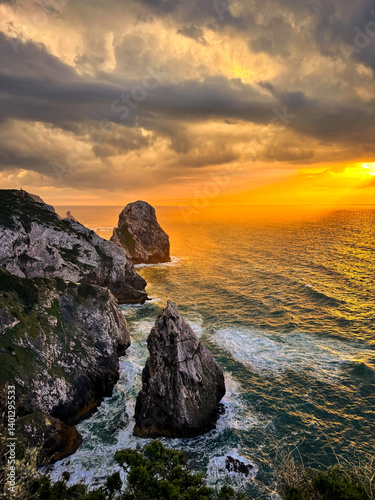  Sunset Over Dramatic Cliffs at Cape Roca, Portugal
Description: Stunning view of golden sunset casting warm light on the steep cliffs and ocean at Cape Roca, the westernmost point of continental Euro photo