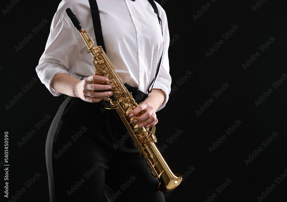 Fototapeta premium Musician with soprano saxophone on dark background, closeup. Space for text