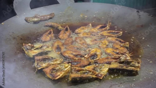 Hilsha fish is fried in a big pan along with shrimp and eggplant, Hilsha Fish and shrimp Simmering in mustard oil, traditional Bengali style fried hilsa and eggplant	