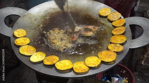 Hilsha fish is fried in a big pan along with shrimp and eggplant, Hilsha Fish and shrimp Simmering in mustard oil, traditional Bengali style fried hilsa and eggplant	