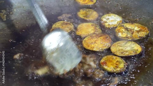 Hilsha fish is fried in a big pan along with shrimp and eggplant, Hilsha Fish and shrimp Simmering in mustard oil, traditional Bengali style fried hilsa and eggplant	