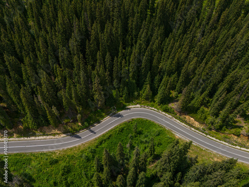 Curve asphalt road on mountain forest summer. Aerial view of the road passing through the mountain and green forest.