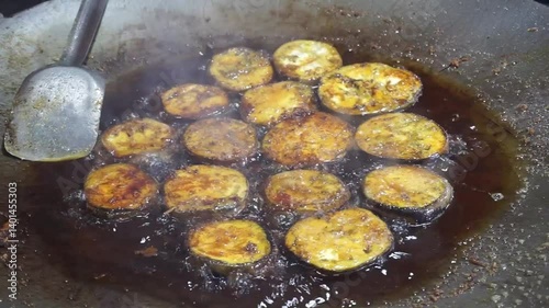 Hilsha fish is fried in a big pan along with shrimp and eggplant, Hilsha Fish and shrimp Simmering in mustard oil, traditional Bengali style fried hilsa and eggplant	