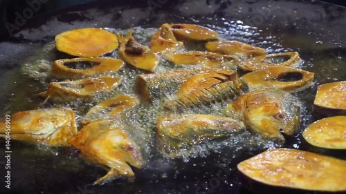 Hilsha fish is fried in a big pan along with shrimp and eggplant, Hilsha Fish and shrimp Simmering in mustard oil, traditional Bengali style fried hilsa and eggplant	