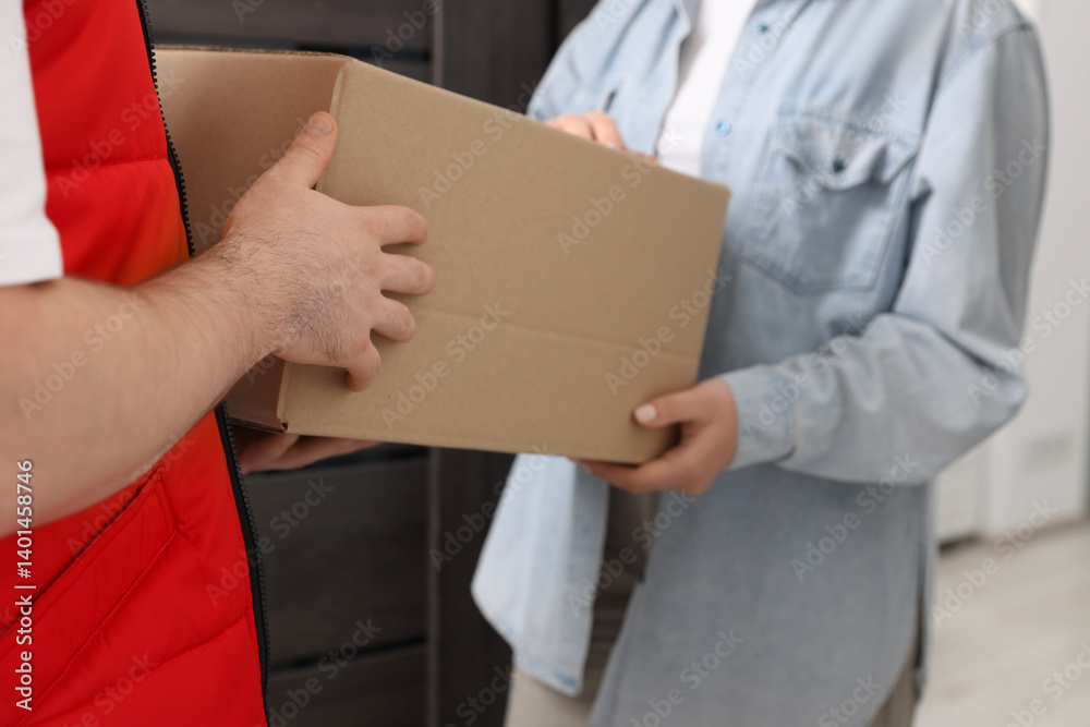 Courier giving parcel to receiver indoors, closeup Courier giving parcel to receiver indoors, closeup