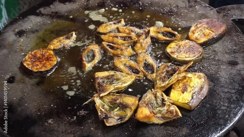 Hilsha fish is fried in a big pan along with shrimp and eggplant, Hilsha Fish and shrimp Simmering in mustard oil, traditional Bengali style fried hilsa and eggplant	