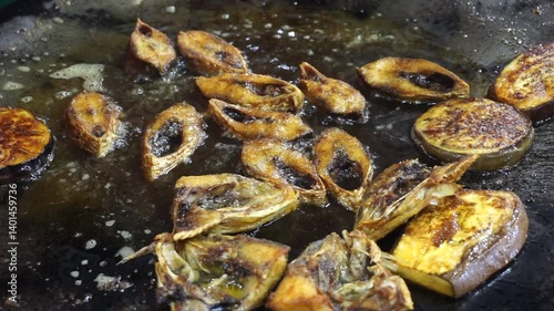 Hilsha fish is fried in a big pan along with shrimp and eggplant, Hilsha Fish and shrimp Simmering in mustard oil, traditional Bengali style fried hilsa and eggplant	