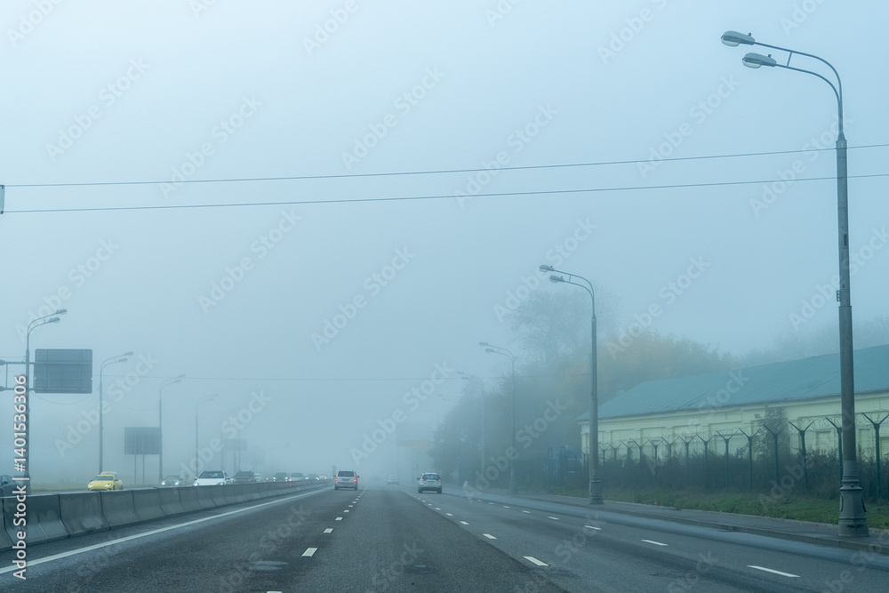 Eerie Autumn Drive: Highway Disappearing into a Dense Fog, Blurred Traffic and Buildings in Distance Eerie Autumn Drive: Highway Disappearing into a Dense Fog, Blurred Traffic and Buildings in Distance