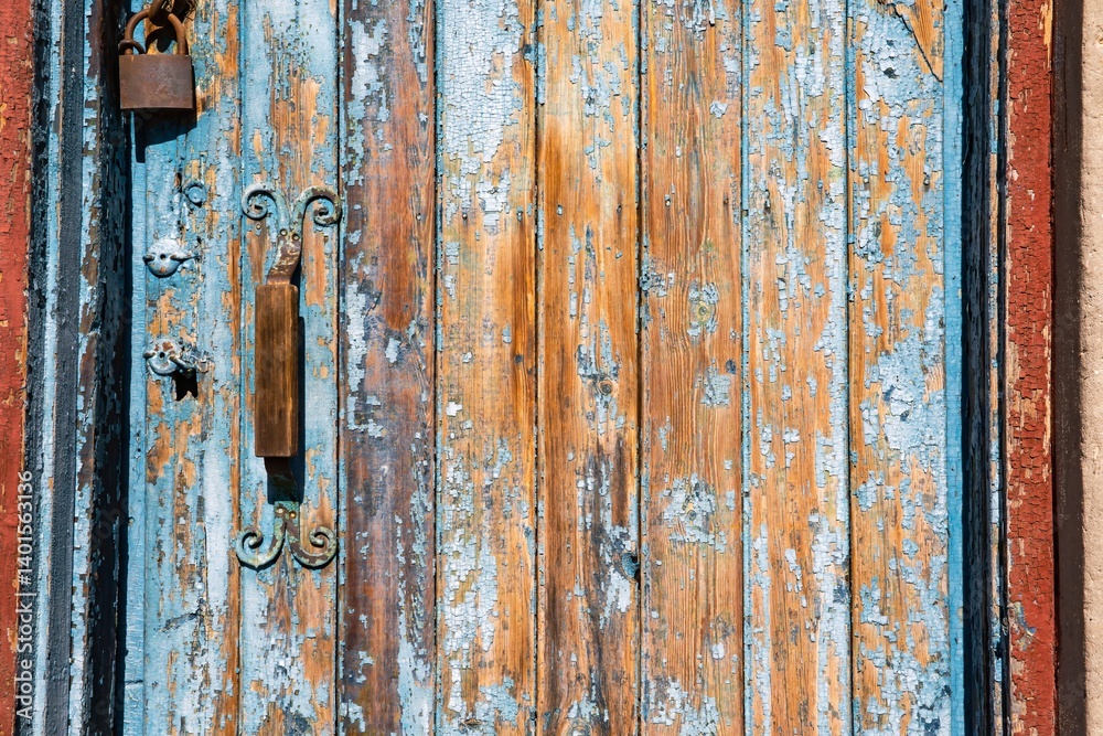 Old weathered wooden door with peeling blue paint and padlock Old weathered wooden door with peeling blue paint and padlock
