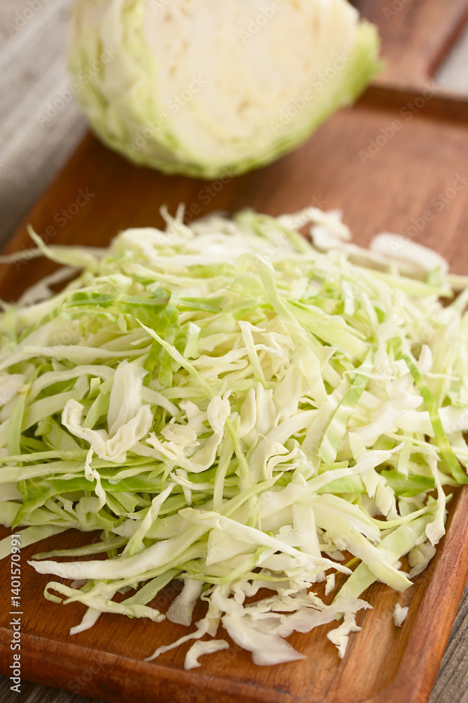 Raw chopped white cabbage on wooden cutting board (Selective Focus, Focus one third into the image) Raw chopped white cabbage on wooden cutting board (Selective Focus, Focus one third into the image)