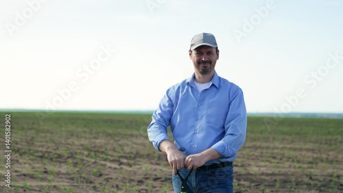 Wallpaper Mural Male farmer smiling with shovel in field. Portrait man on background of field with green fresh corn crops, businessman worker holding shovel smiling broadly contentedly. Fun joyful working as farmer. Torontodigital.ca