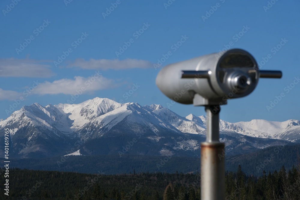 Viewpoint Pass over Lapszanka with snow-capped peaks of High Tatras and Bialskie Tatras mountains and blurred binoculars in foreground, Poland