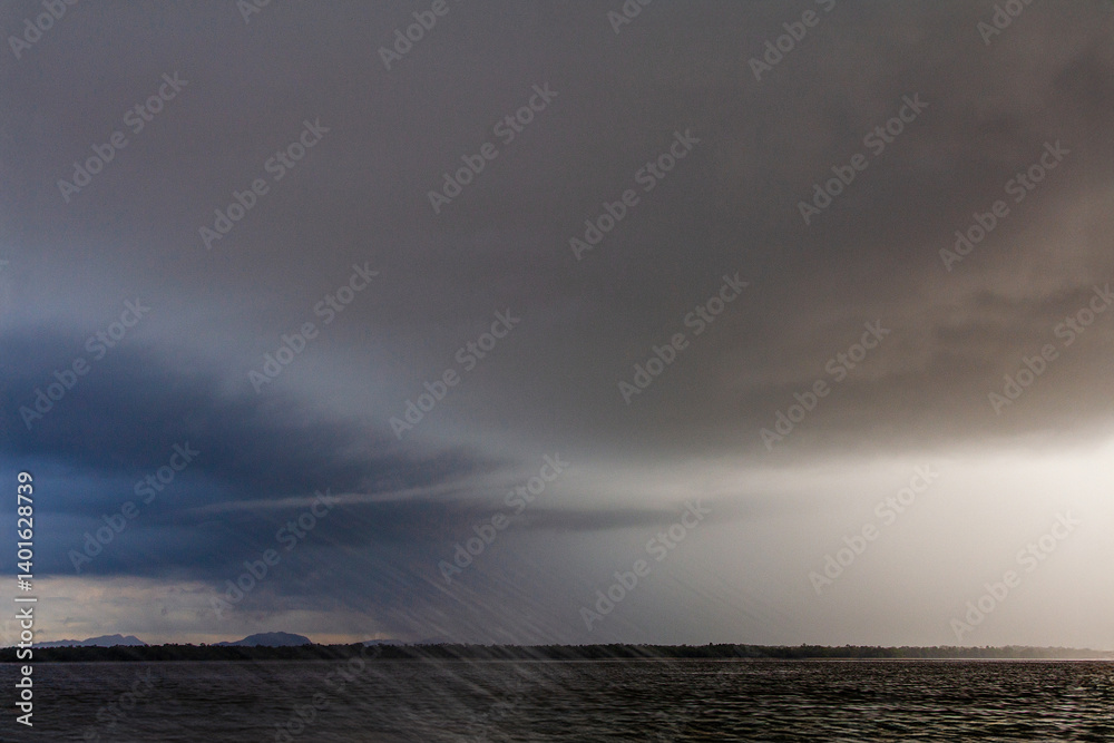Dramatic storm clouds over a calm sea at dusk. A peaceful yet moody seascape with soft light on the horizon, capturing the power and serenity of nature. Dramatic storm clouds over a calm sea at dusk. A peaceful yet moody seascape with soft light on the horizon, capturing the power and serenity of nature.