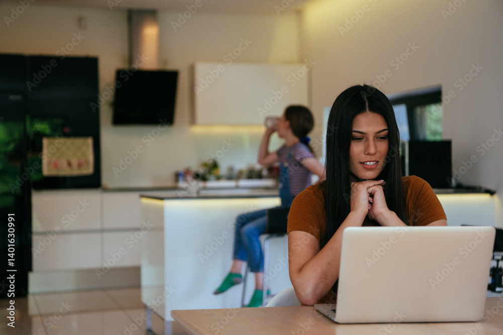 Mother with her daughter talking on laptop with family and friends while sitting in modern living room of big house.