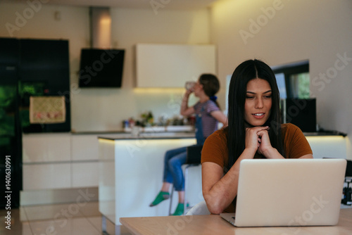 Obraz na płótnie Mother with her daughter talking on laptop with family and friends while sitting in modern living room of big house. w salonie