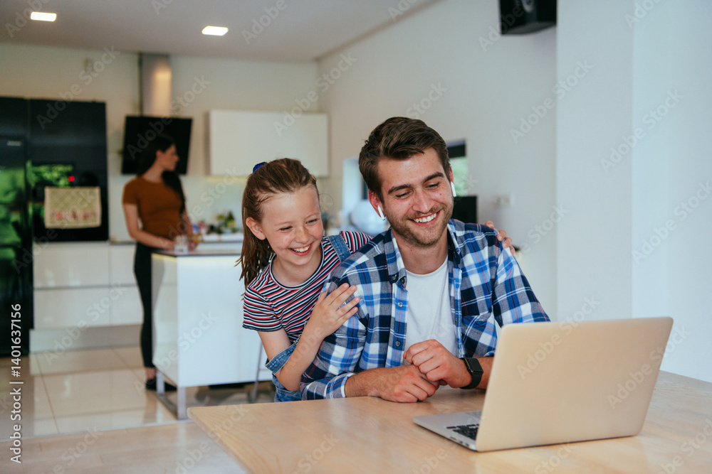 Work from home. Daughter interrupting her father while he is having a business online conversation on his laptop while sitting in the modern living room.