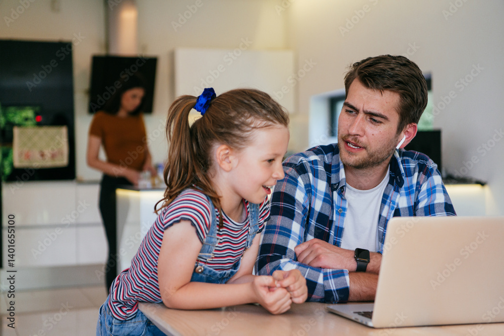 Work from home. Daughter interrupting her father while he is having a business online conversation on his laptop while sitting in the modern living room.