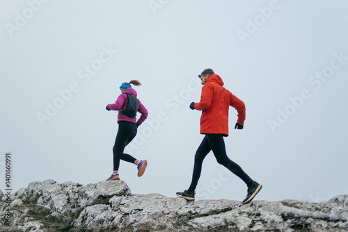 Obraz na płótnie Trail running couple man and woman running on a mountain path w salonie