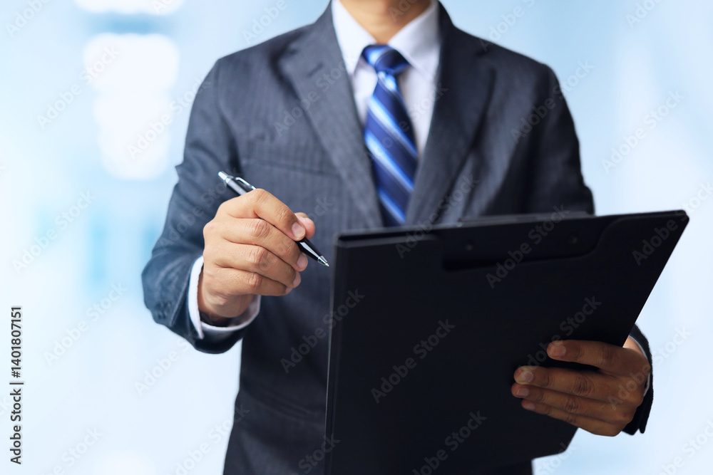 Businessman standing with a black file folder and holding a pen to sign or make an agreement on the document. Businessman standing with a black file folder and holding a pen to sign or make an agreement on the document.