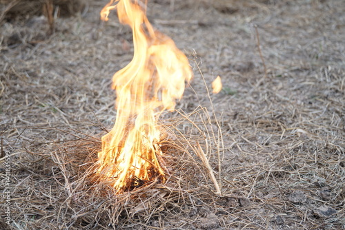 A pile of dry straw set on fire, with flames blazing brightly in a dry environment, reflecting rural life or land preparation for farming.